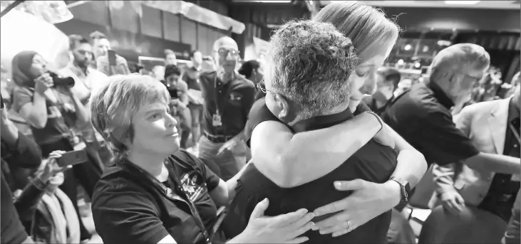  ?? — AFP photo ?? Cassini science team members Nora Alonge (right), Scott Edgington (centre) and Jo Pitesky (left) hug as the final loss of signal from the Cassini spacecraft is confirmed.