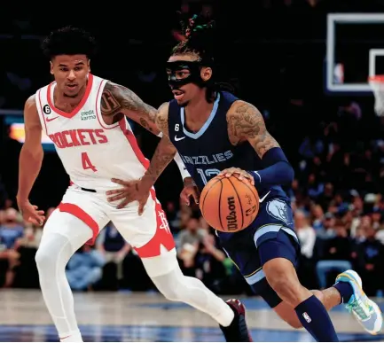  ?? CHRIS DAY/THE COMMERCIAL APPEAL ?? Rockets’ Jalen Green (4) guards Grizzlies’ Ja Morant (12) as he drives to the basket during the game between the Memphis Grizzlies and the Houston Rockets at Fedexforum in Memphis, Tenn., on March 22, 2023.