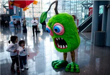  ??  ?? Two children interact with a giant doll during the annual New York Toy Fair, at the Jacob K. Javits Convention Center on February 16, in New York City. – AFP photo