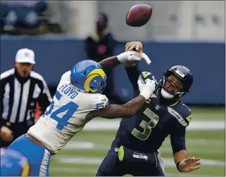  ?? SCOTT EKLUND — THE ASSOCIATED PRESS ?? Rams outside linebacker Leonard Floyd knocks the ball away as Seahawks quarterbac­k Russell Wilson tries to pass during Saturday’s NFC wild- card playoff game in Seattle. Los Angeles won 30-20.