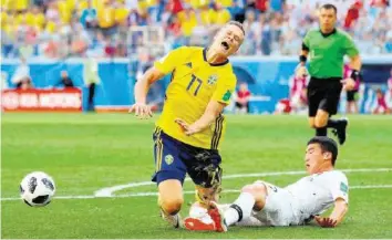  ?? –GETTY IMAGES ?? Kim Min-woo tacle Viktor Claesson. Avec l’aide de la VAR, l’arbitre accorde le penalty.