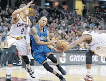  ?? TONY DEJAK/ASSOCIATED PRESS ?? Orlando’s Shabazz Napier, center, is defended by Cleveland’s Jared Cunningham, left, and Tristan Thompson.