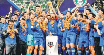  ?? — AFP file photo ?? Jiangsu Suning players and staff members celebrate after their team defeated Guangzhou Evergrande to win the Chinese Super League championsh­ip in Suzhou in China’s eastern Jiangsu province.