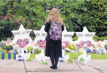  ?? MATT ROURKE/ASSOCIATED PRESS ?? A person stands in front of Stars of David that are displayed in front of the Tree of Life Synagogue on Monday and feature the names of those killed in Saturday’s deadly shooting in Pittsburgh.