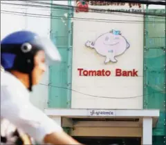  ?? PHA LINA ?? Traffic passes in front of Tomato Specialize­d Bank’s branch in Phnom Penh yesterday.