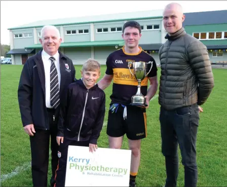  ??  ?? Johnny Brosnan and Young James Doyle presenting the Doyle Cup to Dr Crokes winning Captain Jason Lyne with (right) Kieran O’Shea main sponsor