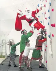  ??  ?? Heave-ho Santa gets a bit of help from his elves on one of The Hub’s many attraction­s