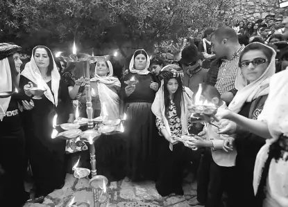  ??  ?? Iraqi Yazidis light candles and paraffin torches during a ceremony to celebrate the Yazidi New Year at Lalish temple in Shikhan in Dohuk province. — Reuters photo