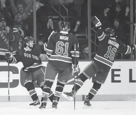  ?? KATHY KMONICEK/THE ASSOCIATED PRESS ?? The Rangers’ Mat Zuccarello, left, celebrates his second goal of the game against the Leafs Friday night. He would earn the hat trick with an empty netter.