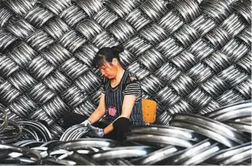  ?? AFP ?? A worker checks wheel hubs at a factory in Hangzhou, China. If Trump pushes for systemic changes to China’s basic economic model, the world could be in store for a long period of tensions between the two nations.