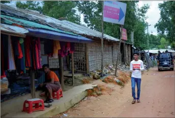  ??  ?? Rafiq walks around the Kutupalong refugee camp in search of content to be recorded with his mobile phone.