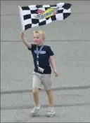  ?? Quinn Harris/ Getty Images ?? Keelan Harvick waves the checkered flag after his dad’s win at Michigan Internatio­nal Speedway.