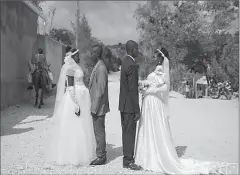  ?? BAIE DE HENNE
-AFP ?? Patricia and Obelson, who got married in a joint ceremony with another couple who they did not know, to share the costs of the ceremony, pose for a photo outside the church where they got married in Haiti.