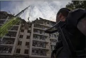  ?? NARIMAN EL-MOFTY — THE ASSOCIATED PRESS ?? Servicemen work at the scene at a residentia­l building following explosions, in Kyiv, Ukraine, Sunday.