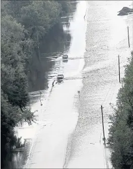  ?? THE ASSOCIATED PRESS ?? Cars make their way down a road topped by rushing floodwater from Hurricane Florence in Dillon, South Carolina. Navigation apps are trying to help motorists avoid flooding.