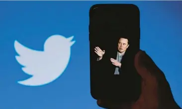  ?? OLIVIER DOULIERY/GETTY-AFP ?? A smartphone shows Elon Musk with Twitter’s logo in the background. With Musk leading the social media platform, public safety personnel now need to convince people that they are legitimate authoritie­s.