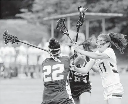  ?? KIM HAIRSTON/BALTIMORE SUN ?? Hannah Shim, left, and Abby Hammond of Marriotts Ridge defend against a shot by McDonogh’s Dani Jacobstein. McDonogh once again made it look easy against a ranked opponent, extending the Eagles’ national-record winning streak to 172 games.