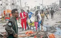  ?? Farah Abdi Warsameh/Associated Press ?? Rescuers remove a body Saturday from the scene of a double car-bomb attack in Mogadishu, Somalia.