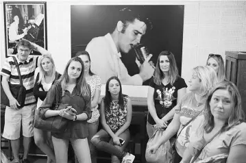 ??  ?? Fans are seen in front of a photo of Elvis Presely during a tour of Sun Studio on Sunday in Memphis, Tennessee.