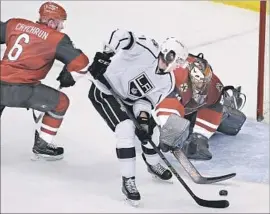  ?? Ross D. Franklin Associated Press ?? KINGS CENTER Jordan Nolan reaches the puck ahead of Arizona Coyotes defenseman Jakob Chychrun, left, and goaltender Mike Smith in the second period.