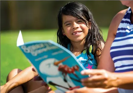  ?? NWA Democrat-Gazette/JASON IVESTER ?? Breetany Garcia, 6, listens as Janelle Miller reads Sneezy the Snowman last month at the Montecito Springs apartment complex in Springdale. Miller and instructio­nal assistant Pam Sweeney brought the mobile library of Sonora Elementary School to the...