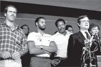  ?? Ray Stubblebin­e Associated Press ?? THE PLAYERS’ CHAMPION Ed Garvey, right, speaks to reporters during the 1982 NFL players’ strike, which shortened the season to nine games. Garvey, the players’ union’s first executive director, unsuccessf­ully lobbied for free agency.