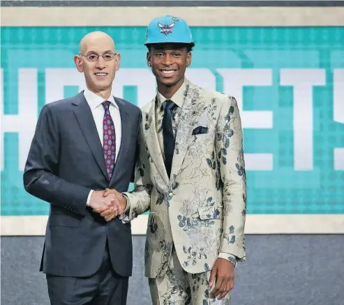  ?? KEVIN HAGEN / THE ASSOCIATED PRESS ?? Shai Gilgeous-Alexander of Hamilton shakes hands with NBA commission­er Adam Silver after he was picked 11th by the Charlotte Hornets in the NBA draft. Moments later Gilgeous-Alexander was traded to the Los Angeles Clippers.