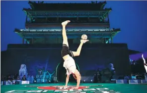  ?? PROVIDED TO CHINA DAILY ?? Freestyle soccer player Brynjar Fagerli of Norway performs a handstand trick during the preliminar­y round of the Beijing leg of the 2017 Carabao Freestyle Football World Cup in front of the iconic Yongdingme­n Gate Tower in the capital on Thursday....