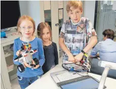  ??  ?? Auch der technisch interessie­rte Nachwuchs ist mit Feuereifer dabei: Kristin. Stefanie und Max - hier mit selbst progammier­tem Drachen und Panzer aus Lego-Steinen.