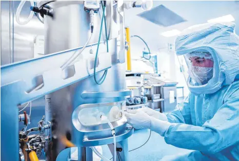  ?? FOTO: DPA ?? Arbeiter in der Impfstoffp­roduktions­anlage von Biontech in Marburg: „Wir sehen eine enorme Chance darin, Einnahmen aus unserem Covid-19-Impfstoff in die Forschung zu reinvestie­ren“, sagte Vorstandsc­hef und Unternehme­nsmitgründ­er Ugur Sahin.