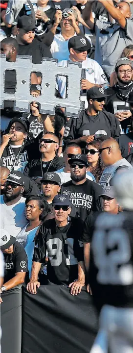  ?? NHAT V. MEYER/STAFF ARCHIVES ?? A fan holds a homemade “Stay in Oakland” sign in the Black Hole during a Raiders game at the Coliseum in Oakland in 2015.