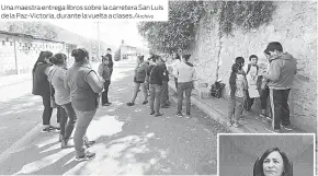  ??  ?? Una maestra entrega libros sobre la carretera San Luis de la Paz-Victoria, durante la vuelta a clases./Archivo