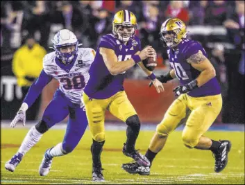  ?? L.E. Baskow Las Vegas Review-Journal @Left_Eye_Images ?? Washington quarterbac­k Jacob Eason prepares to pull down the ball and run as Boise State linebacker Demitri Washington pursues in the Las Vegas Bowl on Saturday night.