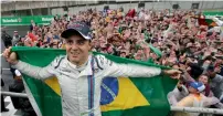  ?? Reuters ?? Williams’ Felipe Massa of Brazil wears his country’s flag over his shoulders as he celebrates with fans after the race. —