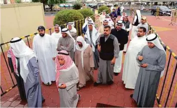  ?? Reuters ?? Men wait to cast their votes in Kuwait City yesterday. A total of 483,000 people are eligible to vote in the parliament­ary elections.