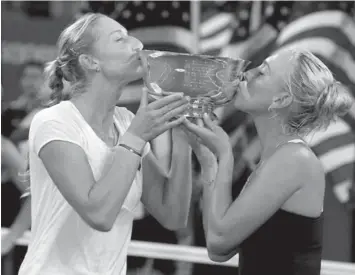  ?? ASSOCIATED PRESS ?? Elena Vesnina, right, and Ekaterina Makarova, of Russia, kiss the championsh­ip trophy after winning the women's doubles final over Flavia Pennetta, of Italy, and Martina Hingis, of Switzerlan­d, at the 2014 U.S. Open tennis tournament in New York.