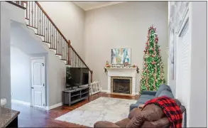  ?? ?? Highlights of the living room include a double-height ceiling, two windows, two clerestory windows and a gas-log fireplace.