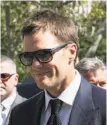  ?? Andrew Burton / Getty Images ?? Tom Brady smiles as he arrives at federal court.