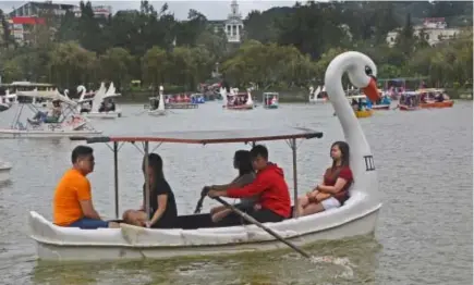  ?? Photo by Milo Brioso ?? LONG WEEKEND. Rain or shine, Pinoy travelers take advantage of the long weekend and flock to the Summer Capital to experience boat rides at the Burnham Lake.