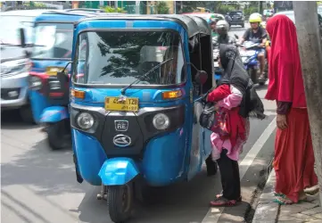  ??  ?? Photo shows Indonesian women trying to haggle for a good price before using a three-wheeled bajaj taxi in Jakarta. There were some 14,000 bajaj on Indonesia’s roads by 2015, according to the latest official figures, but ride-hailing apps in Southeast...