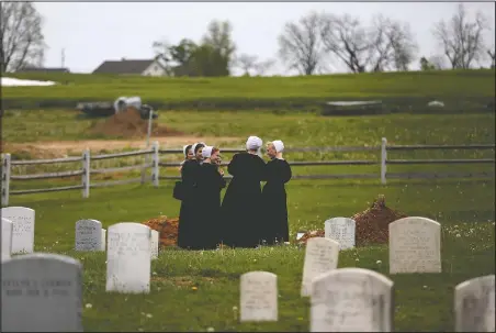  ?? (File Photo/AP/Jessie Wardarski) ?? A group of friends visit the grave of a fellow Old Order Stauffer Mennonite member in a cemetery next to the church in New Holland, Pa. The women were among dozens of other congregant­s who attended the church’s first in-person service since the start of the coronaviru­s outbreak in March.