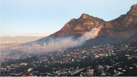  ?? NARDUS ENGELBRECH­T AP ?? People were evacuated from some neighborho­ods in Cape Town, South Africa, Monday as a wildfire swept across the slopes of the city’s famed Table Mountain. The blaze, which started Sunday, burned the library and other buildings on the University of Cape Town campus.