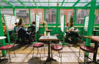  ?? Mary Altaffer / Associated Press ?? Customers have lunch in an outdoor seating area of a restaurant Tuesday in the Greenwich Village neighborho­od of Manhattan in New York. Teams of experts are projecting COVID’S toll on the U.S. will fall sharply by the end of July, according to research.