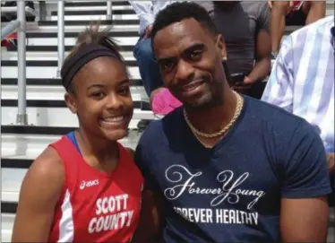  ?? MARK MALONEY — LEXINGTON HERALD-LEADER VIA AP, FILE) — LEXINGTON HERALD-LEADER VIA AP ?? In this May 3, 2014 photo, Trinity Gay, a seventh-grader racing for her Scott County High School team, poses for a photo with her father, Tyson Gay, after she won the 100 meters and was part of the winning 4-by-100 and 4-by-200 relays at the meet in...