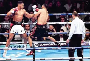  ?? PAUL ELLIS/AFP ?? Anthony Joshua lands a left on Eric Molina in their IBF world heavyweigh­t boxing match in Manchester, northwest England, on Saturday night.