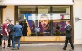  ?? MARKUS SCHREIBER/AP ?? Ukrainian President Volodymyr Zelenskyy speaks on a screen inside the “Russian War Crimes House” on Sunday near the site of the World Economy Forum.