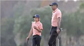  ?? JEREMY REPER / USA TODAY SPORTS ?? Charlie Woods and his dad, Tiger, wait on the 12th green during the first round of the PNC Championsh­ip golf tournament Saturday.