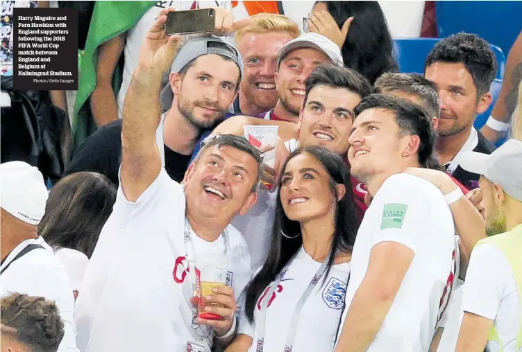  ?? Photos / Getty Images ?? Harry Maguire and Fern Hawkins with England supporters following the 2018 FIFA World Cup match between England and Belgium at Kaliningra­d Stadium.