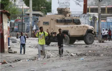  ?? ?? Youths raise their hands to show police they are not carrying weapons during an anti-gang operation on Feb. 29 at the Portail neighborho­od in Port-au-Prince, Haiti. (AP Photo/Odelyn Joseph)