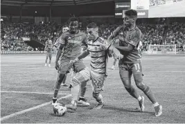  ?? JAY BIGGERSTAF­F USA TODAY Sports ?? Sporting Kansas City midfielder Erik Thommy, center, is defended by St. Louis City SC forward Nicholas Gioacchini during a 2023 MLS Cup playoff match at Children’s Mercy Park in Kansas City, Kan.